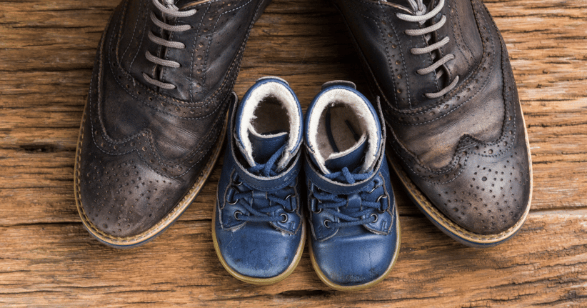 Big shoes next to tiny shoes