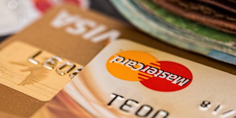 A stack of beige and gold credit cards on a table.